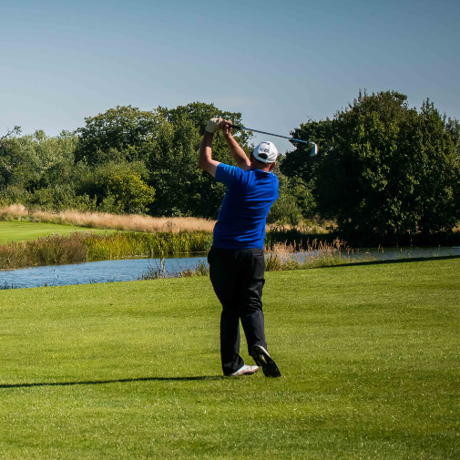 A greens golf course with a golfer swing